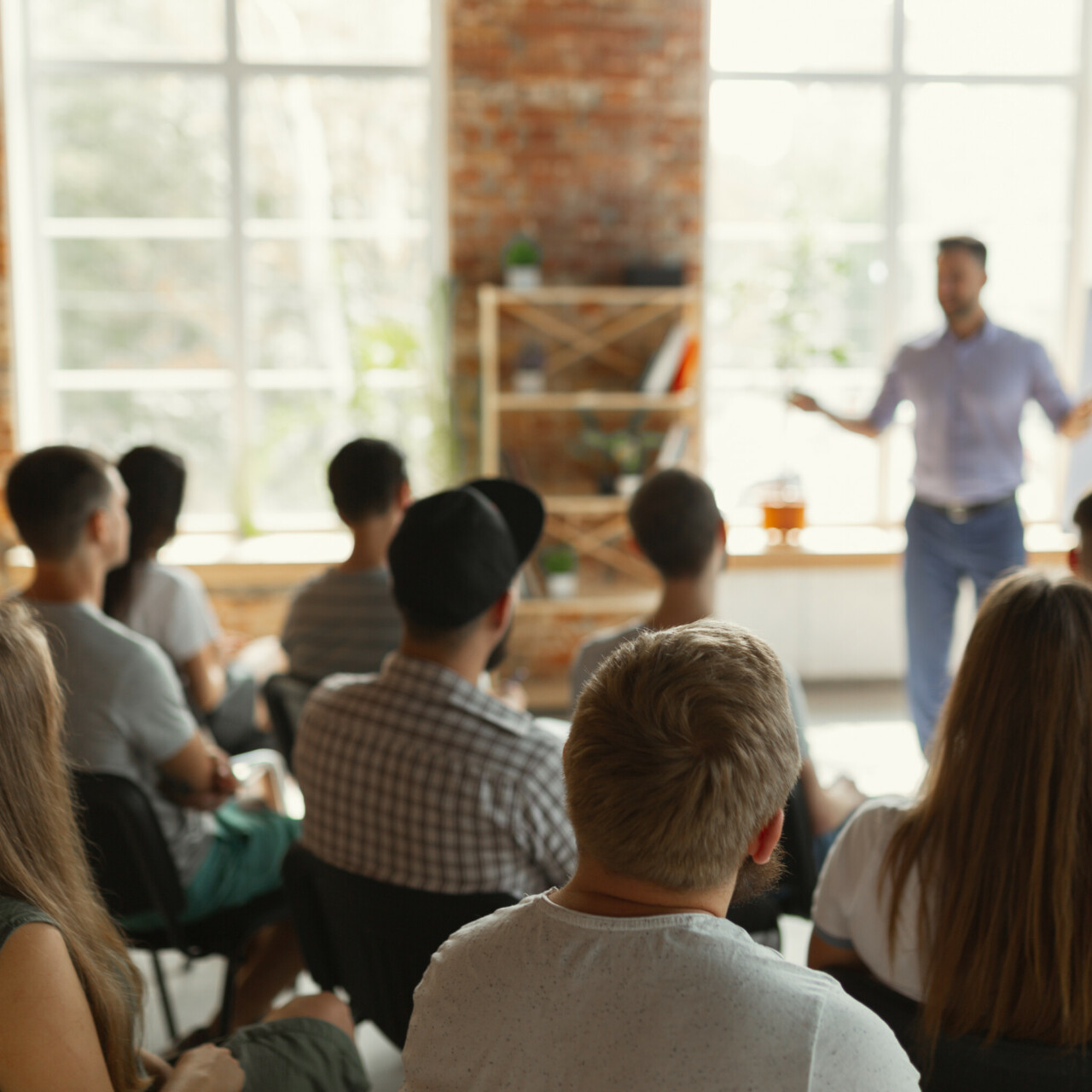 Male speaker giving presentation in hall at university workshop